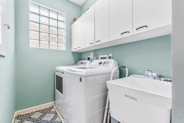 clothes washing area featuring cabinets, washer and clothes dryer, and sink