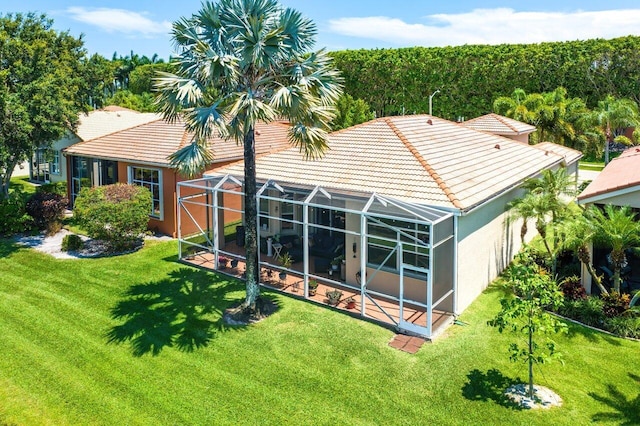 back of property with a lawn and a lanai