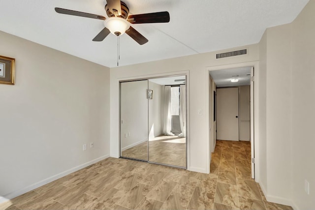 unfurnished bedroom featuring a textured ceiling, a closet, and ceiling fan