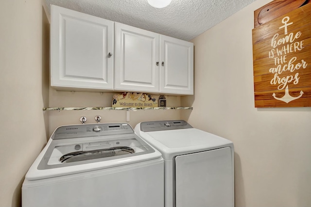 clothes washing area with cabinets, independent washer and dryer, and a textured ceiling