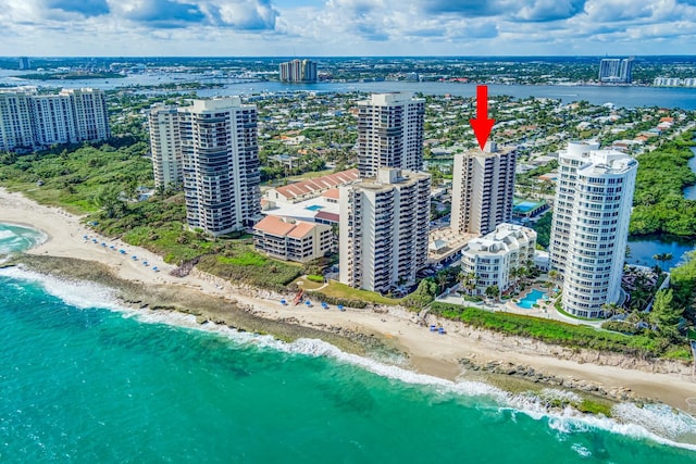 birds eye view of property with a water view and a view of the beach