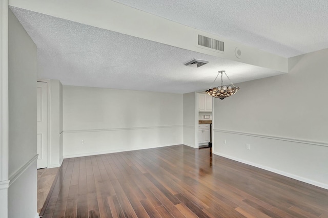 unfurnished room featuring dark hardwood / wood-style floors and a textured ceiling