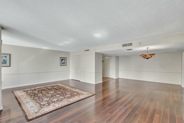 spare room with dark wood-type flooring and a textured ceiling