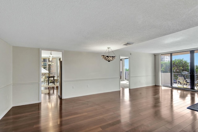 4200 N Ocean Dr Unit 2-202, Singer Island, FL 33404 - unfurnished room with a chandelier, a textured ceiling, wood finished floors, and baseboards