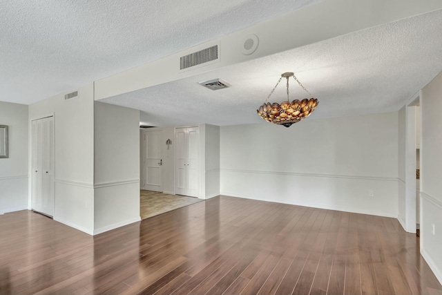 4200 N Ocean Dr Unit 2-202, Singer Island, FL 33404 - unfurnished room featuring a textured ceiling, wood finished floors, baseboards, and a chandelier