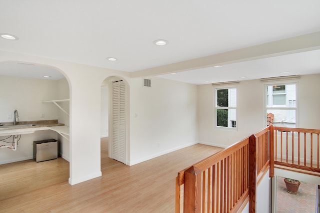 hall featuring light wood-type flooring and sink