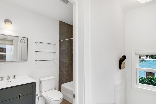 full bathroom with vanity, tiled shower / bath combo, and toilet