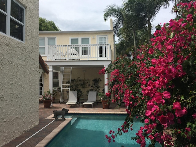 rear view of house featuring a patio and a balcony