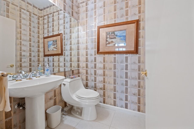 bathroom with tile patterned floors, sink, toilet, and tile walls