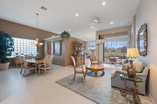 tiled living room with ceiling fan with notable chandelier