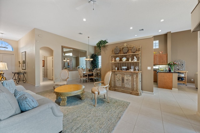 living room with ceiling fan, light tile patterned floors, and a healthy amount of sunlight