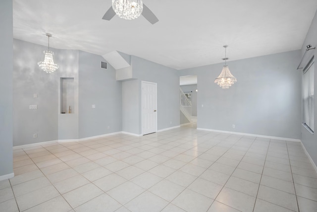 tiled empty room with ceiling fan with notable chandelier and lofted ceiling