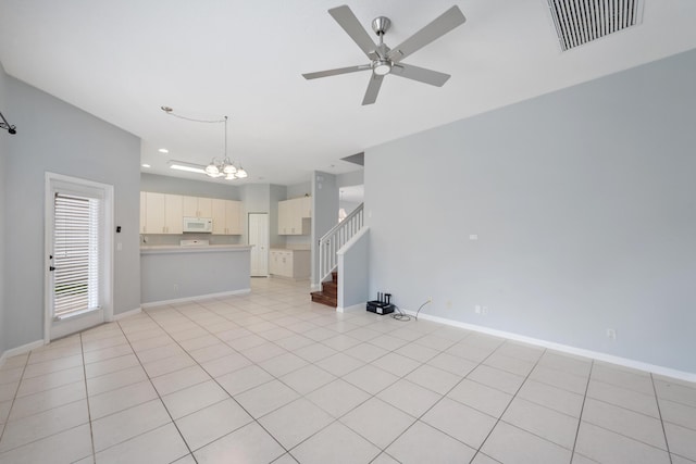 unfurnished living room with ceiling fan with notable chandelier and light tile patterned floors