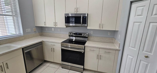 kitchen with light tile patterned floors, sink, and appliances with stainless steel finishes