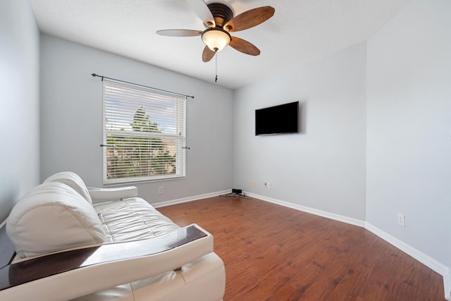 living area featuring hardwood / wood-style floors and ceiling fan