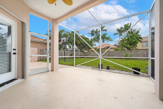 unfurnished sunroom featuring ceiling fan