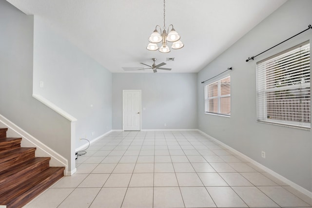 spare room featuring ceiling fan with notable chandelier and light tile patterned floors