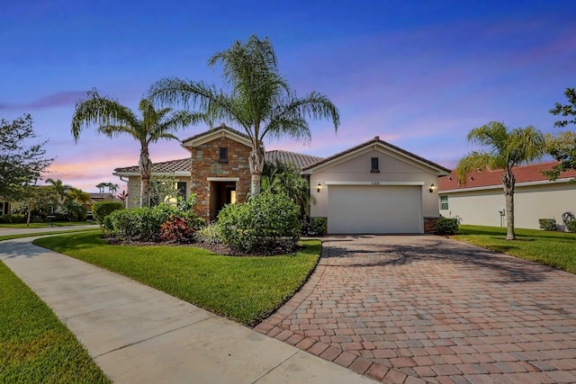 view of front of house with a garage and a lawn