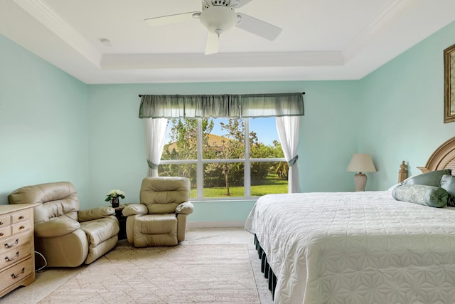 carpeted bedroom with ceiling fan, ornamental molding, and a tray ceiling