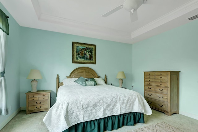 carpeted bedroom with a raised ceiling, ornamental molding, and ceiling fan