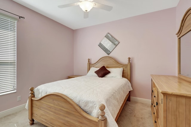 bedroom featuring multiple windows, ceiling fan, and light colored carpet