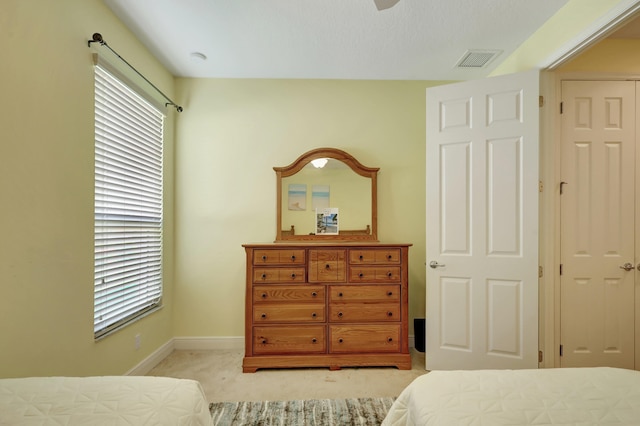 bedroom featuring light colored carpet and multiple windows