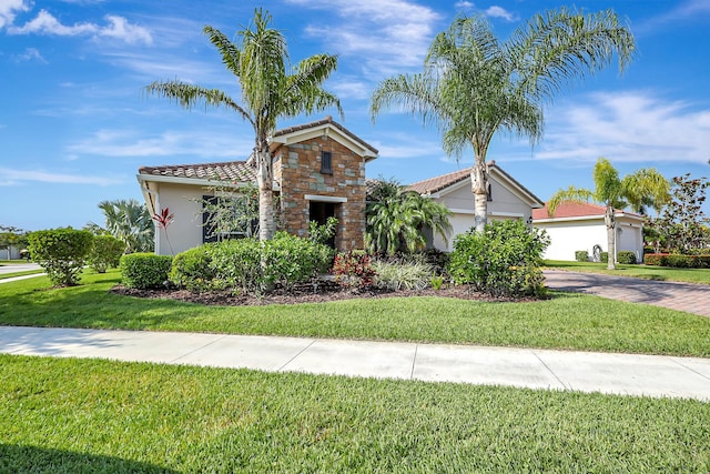 mediterranean / spanish house with a garage and a front yard