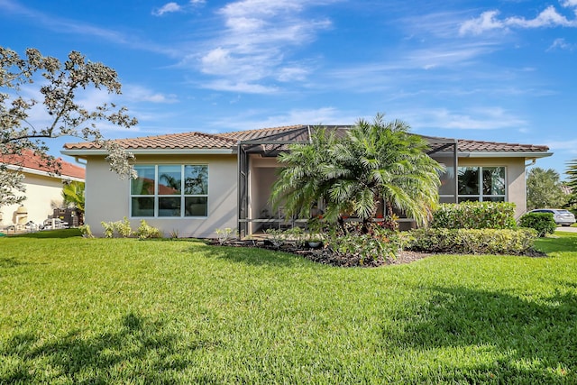 exterior space featuring a front lawn and glass enclosure