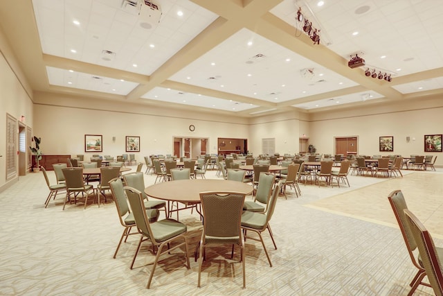 dining room featuring a towering ceiling, beam ceiling, and light carpet