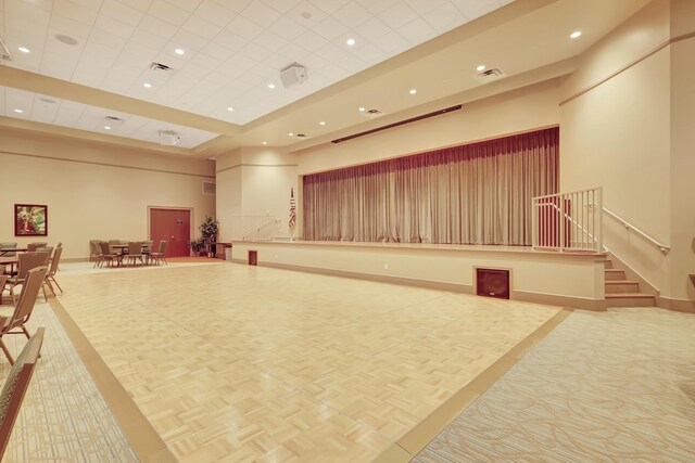 carpeted dining space featuring beam ceiling, a high ceiling, and coffered ceiling