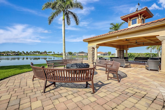 view of patio / terrace featuring a gazebo, outdoor lounge area, ceiling fan, and a water view