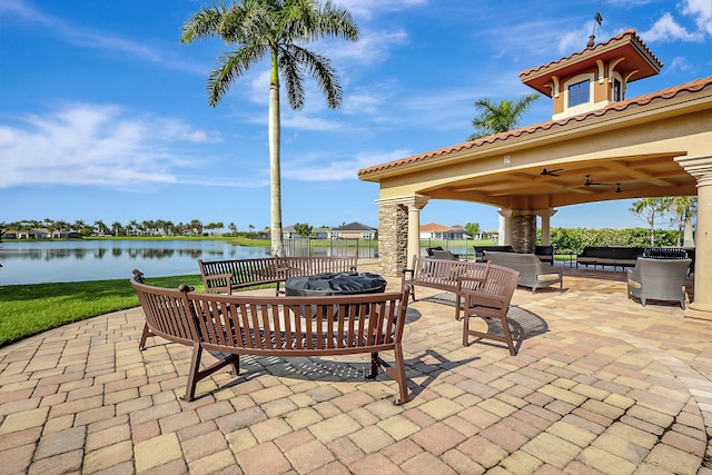 view of patio with a gazebo, an outdoor living space, a water view, and ceiling fan