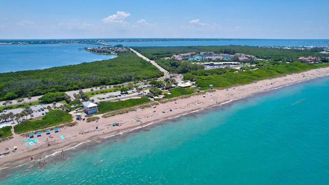 birds eye view of property with a water view and a beach view