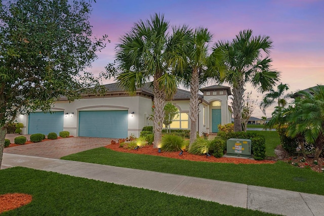 mediterranean / spanish-style house featuring a lawn and a garage