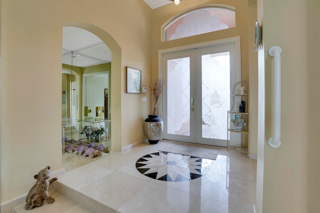 tiled entrance foyer with french doors, a wealth of natural light, and crown molding