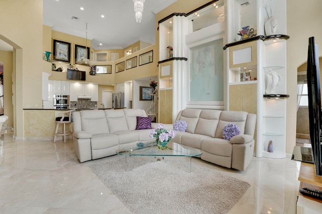 living room featuring a towering ceiling and ornamental molding