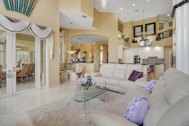 living room with a high ceiling and crown molding