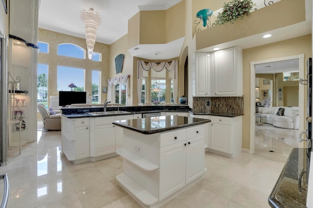 kitchen featuring white cabinets, a center island, a wealth of natural light, and sink