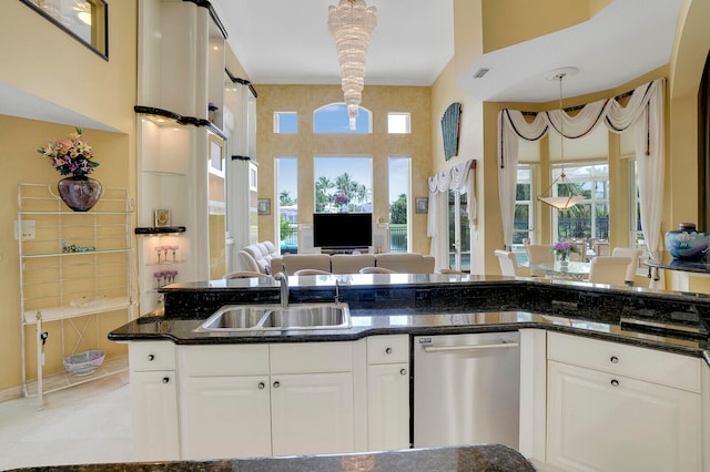 kitchen with decorative light fixtures, white cabinetry, stainless steel dishwasher, and sink