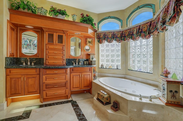 bathroom featuring tile patterned floors, tiled bath, and vanity