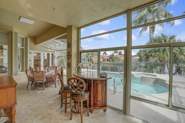 sunroom / solarium with vaulted ceiling with beams and french doors