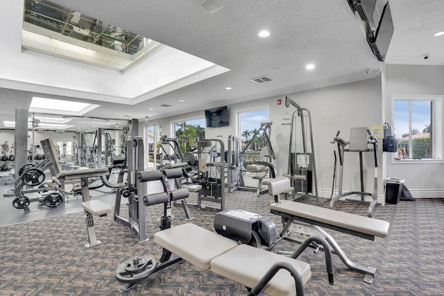 exercise room featuring carpet, a textured ceiling, and ornamental molding