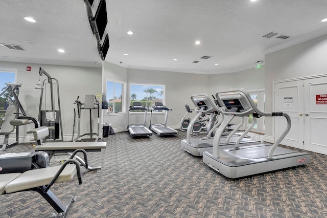 gym featuring crown molding, dark carpet, and a textured ceiling