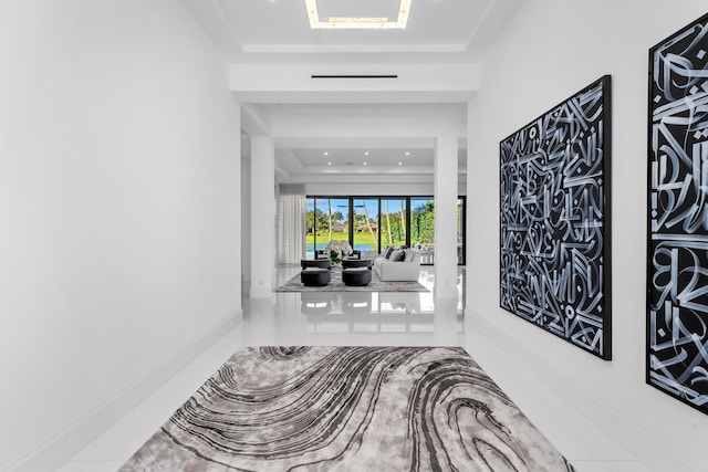 hall featuring a tray ceiling and tile patterned floors