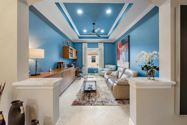 tiled living room with a tray ceiling and crown molding