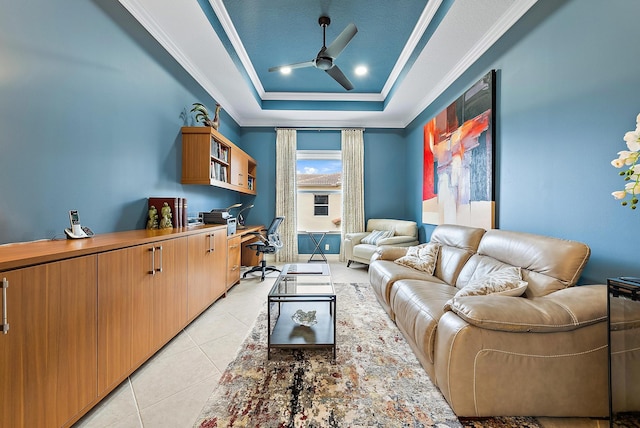 home theater room featuring a raised ceiling, ceiling fan, crown molding, and light tile patterned floors