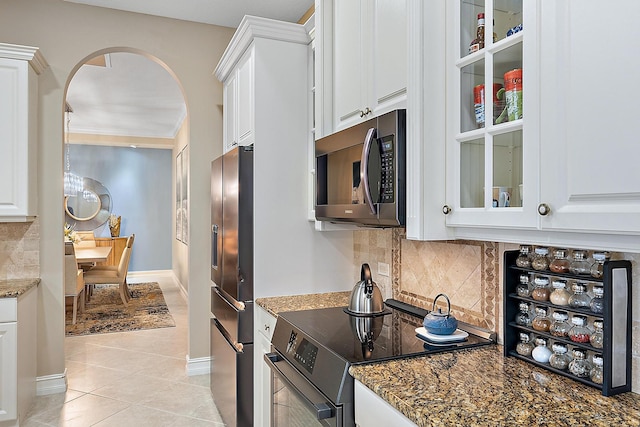 kitchen with appliances with stainless steel finishes, light tile patterned floors, and white cabinetry