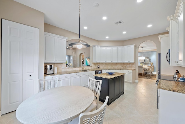 kitchen featuring decorative backsplash, white cabinetry, and sink