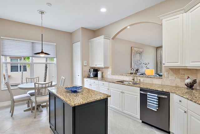 kitchen featuring white cabinetry, sink, tasteful backsplash, light stone counters, and stainless steel dishwasher