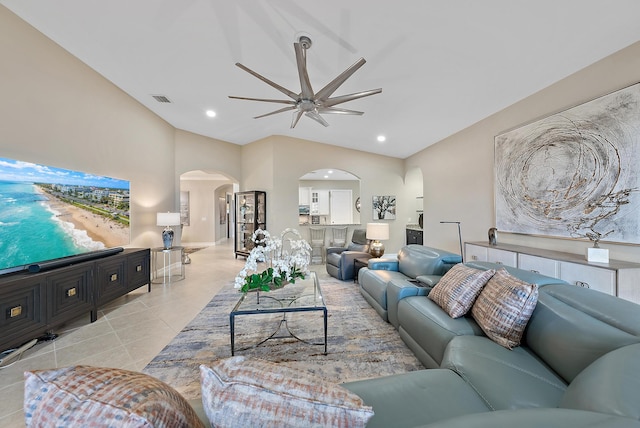 living room with ceiling fan, light tile patterned floors, and lofted ceiling